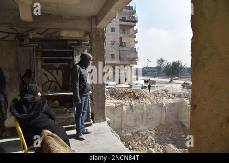 Saleppo, Siria. 13th Feb, 2023. Ali Abdul-Rahman si trova sul lato del suo portico distrutto presso la sua casa nel quartiere di Masharqa nella città di Aleppo, Siria settentrionale, 13 febbraio 2023. Mucchi di detriti del terremoto hanno dato ad Ali Abdul-Rahman, un sopravvissuto nella Siria settentrionale, un duro flashback alla seconda morte, quando è scappato da un muro fatiscente a casa, e come il muro condiviso da due edifici ha tenuto amici e vicini parte.PER ANDARE CON 'Feature: Come un muro in Aleppo Siria separa la vita dalla morte in tragico terremoto' credito: Monsef Memari/Xinhua/Alamy Live News Foto Stock