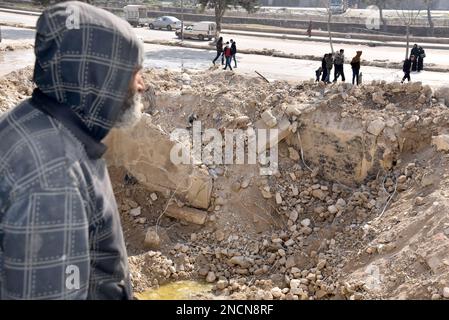 Saleppo, Siria. 13th Feb, 2023. Ali Abdul-Rahman si trova sul lato del suo portico distrutto presso la sua casa nel quartiere di Masharqa nella città di Aleppo, Siria settentrionale, 13 febbraio 2023. Mucchi di detriti del terremoto hanno dato ad Ali Abdul-Rahman, un sopravvissuto nel nord della Siria, un duro flashback al secondo vicino-morte quando è sfuggito ad un muro fatiscente in casa, e come il muro condiviso da due edifici ha tenuto gli amici e vicini parte. PER ANDARE CON 'caratteristica: Come un muro in Siria Aleppo separa la vita dalla morte in tragico terremoto' Credit: Monsef Memari/Xinhua/Alamy Live News Foto Stock