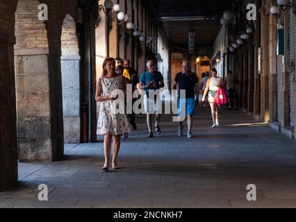 Pamplona, Spagna - Agosto, 01, 2022: Persone che camminano nel colonnato ad arco dalla storica piazza del Castillo nella città vecchia, Pamplona Foto Stock