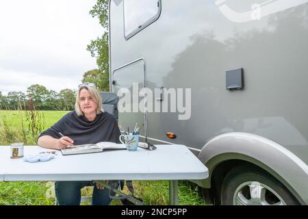 La rinomata artista commerciale Jo Scott abbandona il suo studio per migliorare l'equilibrio della vita lavorativa. Lavorare ovunque nel suo stato dell'arte, motorhome connesso Foto Stock