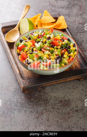 Insalata di caviale dei cowboy o caviale del texas con fagiolo nero, pomodori, avocado, peperone rosso e verde, granoturco, coriandolo di garza nella ciotola sulla teglia Foto Stock