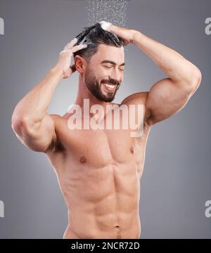 Doccia, shampoo e capelli lavanti con un uomo in studio su sfondo grigio per l'igiene o la cura del corpo. Acqua, cura dei capelli e pulizia con un felice o. Foto Stock