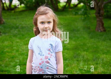 Una ragazza di cinque anni in una giornata estiva per strada. Spazio di copia Foto Stock