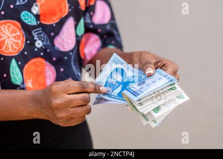 una signora che conta le nuove note nigeriane della nigeriana Foto Stock