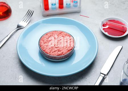 Carne coltivata servita su un tavolo da laboratorio grigio chiaro Foto Stock