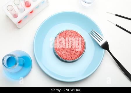 Carne coltivata macinata servita su un tavolo da laboratorio bianco, piatto Foto Stock