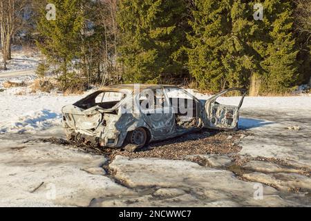 Naufragato abbandonato auto bruciata con danni da fuoco sul lato della strada. Foto Stock