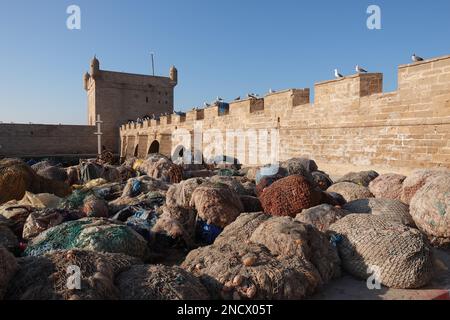 Reti da pesca sullo sfondo delle mura del porto di Essaouria Foto Stock