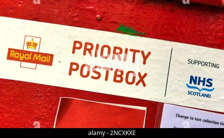 adesivo priority postbox sulla casella postale reale rossa con supporto nhs Foto Stock