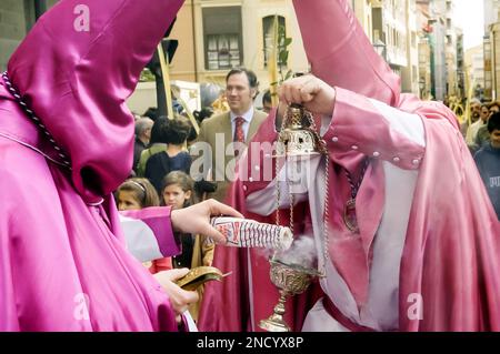 Settimana Santa a Zamora, Spagna. L'incenso tenuto in mano a un penitente viene versato in una censura nella processione borriquita. Foto Stock