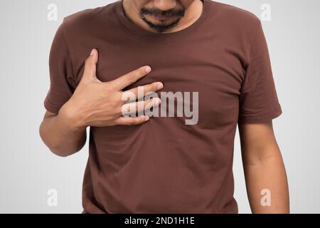 Uomo asiatico affetto da gastrite su sfondo grigio. Foto Stock