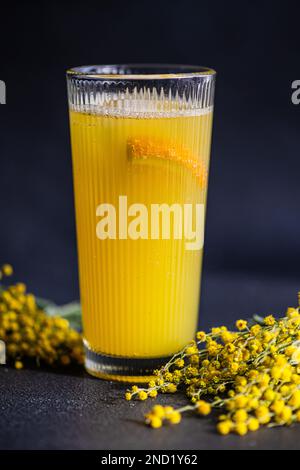 Primo piano del cocktail Mimosa in vetro sul tavolo in pietra nera Foto Stock