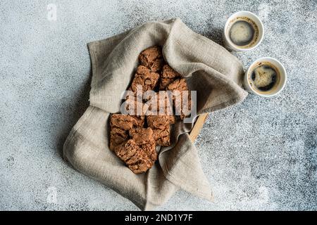 Tazza di caffè e biscotti al cioccolato nella scatola per la colazione su fondo in cemento Foto Stock