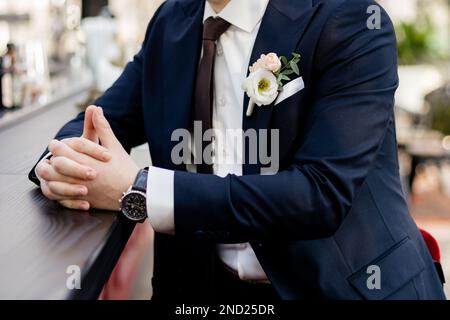 lo sposo in un vestito è seduto al bar in attesa della sposa al matrimonio Foto Stock