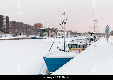 Piccole barche sono ormeggiate sulla costa del fiume Aura in una giornata invernale. Turku, Finlandia Foto Stock