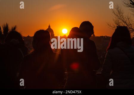 Roma, Italia. 14th Feb, 2023. Le coppie osservano il tramonto dal lungomare vicino alla Terrazza Pincio il giorno di San Valentino, con San La cupola di Pietro sullo sfondo. (Credit Image: © Matteo Nardone/Pacific Press via ZUMA Press Wire) SOLO PER USO EDITORIALE! Non per USO commerciale! Foto Stock