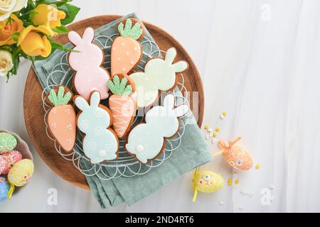 Colazione di Pasqua, concetto di Holliday. Pan di zenzero pasquale forma di coniglietto e carota con cannella con smalto colorato, decorazioni pasquali, uova colorate su Foto Stock