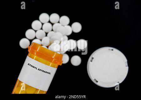 Ethinyl Estradiol Rx pillole mediche in flacone plactico con compresse. Pillole che fuoriescono dal contenitore giallo. Foto Stock