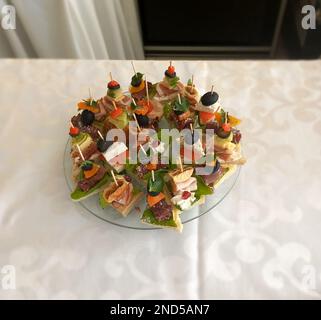 Spuntini assortiti serviti su un tavolo con una tovaglia bianca in un ristorante Foto Stock