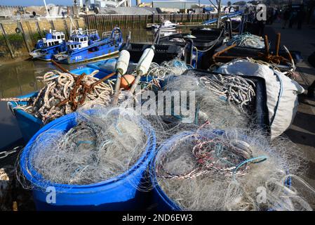 Whitstable, Kent, Inghilterra, Regno Unito. Reti da pesca, corda e ancoraggi in cesti sulla parete del porto Foto Stock