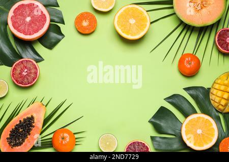 Cornice di diversi frutti esotici su sfondo verde, piatto. Spazio per il testo Foto Stock