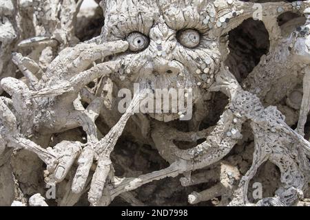 Scultura di faccia spettrale a Wat Rong Khun, Chiang Rai, Thailandia. Foto Stock