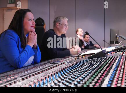 15 febbraio 2023, Brandeburgo, Potsdam: Manja Schüle (l, SPD), Ministro della Scienza, della Ricerca e della Cultura del Brandeburgo, segue l'esecuzione del titolo musicale di 'solo Sunny' nella sala di controllo del Deutsches Filmorchester Babelsberg (DFOB) presso la nuova console di mixaggio analogico 'neve 88RS' accanto all'ingegnere del suono Falko Duzmal. Sulla destra si trova Klaus-Peter Beyer, direttore artistico della DFOB. Una console di mixaggio analogico, a differenza di una digitale, è ancora lo standard internazionale per la velocità, le caratteristiche audio e la sensazione. Il Ministero della Cultura del Brandeburgo aveva sostenuto il nuovo Foto Stock