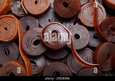 Deliziosi rotoli di pelle di frutta come sfondo, primo piano Foto Stock