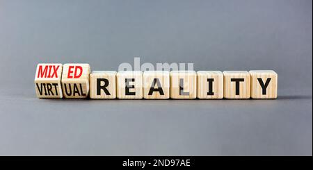 Simbolo di realtà mista o virtuale. Parole di concetto realtà mista realtà virtuale su cubi di legno. Bellissimo sfondo grigio tavolo. Business misto o. Foto Stock