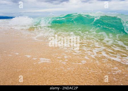 Vista ad angolo basso di un'onda di rottura su una spiaggia di sabbia Foto Stock