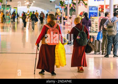 Due donne più anziane che indossano abiti colorati camminano all'aeroporto di Suvarnabhumi, ora del giorno. BANGKOK, THAILANDIA - 31 DICEMBRE 2019 Foto Stock