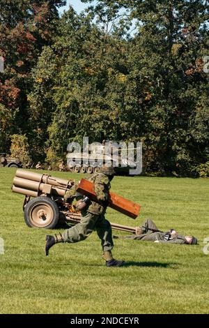 Soldati che corrono su un campo di battaglia della seconda guerra mondiale durante una rievocazione presso l'American Heritage Museum. Hudson, Massachusetts Foto Stock