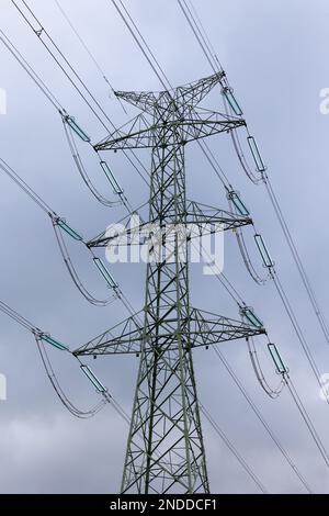 La silhouette di un pilone ad alta tensione contro un cielo completamente nuvoloso. Sviluppo di reti di trasmissione ad alta tensione Foto Stock