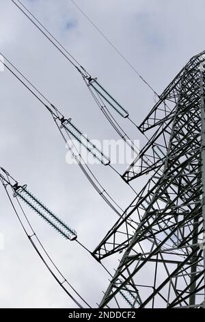 La silhouette di un pilone ad alta tensione contro un cielo completamente nuvoloso. Sviluppo di reti di trasmissione ad alta tensione Foto Stock