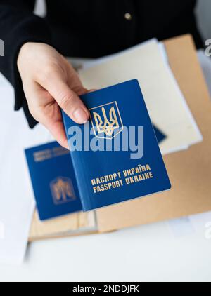 Lviv, Ucraina - 23 gennaio 2023: Passaporto ucraino in mano sullo sfondo dei documenti. Passaporto di un cittadino ucraino. Iscrizione in Ucraina Foto Stock