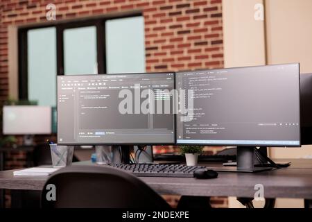 PC desk con monitor per pc che eseguono la finestra terminale e script per database di programmazione con intelligenza artificiale. Svuotate l'ufficio della società di programmazione IT con il cloud computing dei server. Concetto di codifica Foto Stock