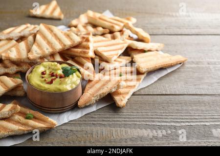 Deliziose patatine fritte e hummus sul tavolo di legno Foto Stock