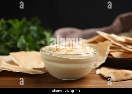 Delizioso hummus con patatine pita sul tavolo di legno Foto Stock