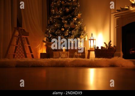 Bell'albero di Natale con regali in una stanza poco illuminata Foto Stock