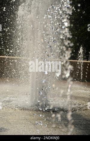 L'acqua sospesa cade dall'aria da una fontana sfocata Foto Stock