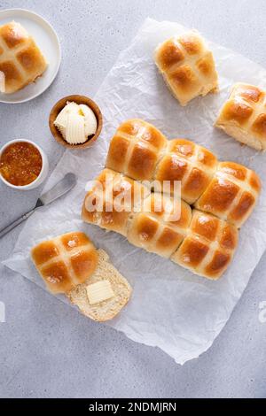 Tradizionali panini caldi appena sfornati per il brunch pasquale serviti con burro e marmellata d'arance Foto Stock