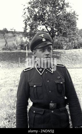 Un ufficiale della SS totenkopf si pone per una foto al campo di concentramento di Mauthausen. L'unità di guardia Totenkopf era un'unità separata all'interno delle SS ed era responsabile della gestione dei campi di concentramento e di sterminio. Si distinguono per l'emblema della testa della morte sul loro bavero. La divisione SS Panzer del 3rd portava il nome di Totenkopf, ma era un'unità combattente non coinvolta nell'amministrazione dei campi. Foto Bundesarchiviv, Bild 192-025 / CC-BY-SA 3,0, CC BY-SA 3,0 de, https://commons.wikimedia.org/w/index.php?curid=5485423 Foto Stock