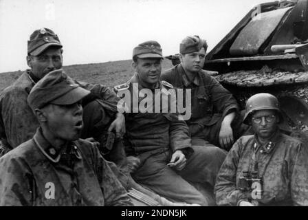 Soldati della 3rd SS Panzer divisione 'Totenkopf' a riposo accanto a un carro armato sovietico distrutto T-34 in Romania nel 1944. Foto Bundesarchiv Bild 101i-024-3535-30, Ostfront, Waffen-SS-Angehörige bei Rast.jpg Foto Stock