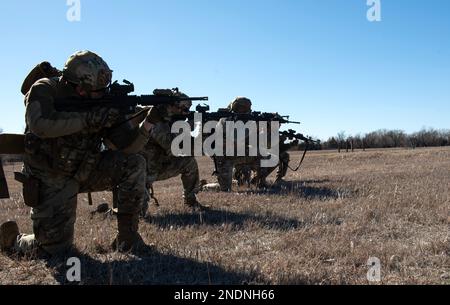 I militari dello Squadron delle forze di sicurezza del 22nd forniscono copertura ai membri della loro squadra durante l'addestramento congiunto alla base aeronautica di McConnell, Kansas, 3 febbraio 2023. Insieme agli approcci tattici e ai ritiri per pulire gli edifici, gli Airmen si sono allenati con il battaglione dell'elicottero Assault 3rd, il reggimento dell'aviazione 1st di Fort Riley, Kansas, per praticare decolli tattici e atterraggi in un UH-60 Blackhawk. (STATI UNITI Air Force foto di staff Sgt. Tryphena Mayhugh) Foto Stock