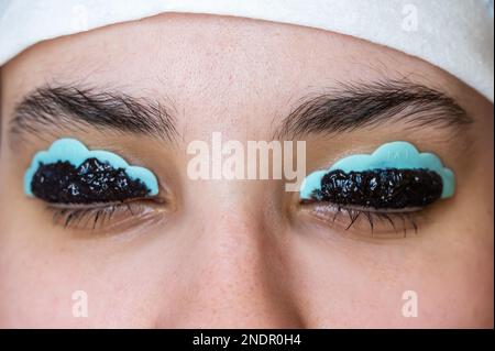 Primo piano ritratto di una donna sulla procedura di laminazione e tintura delle ciglia. Trucco permanente. Foto Stock