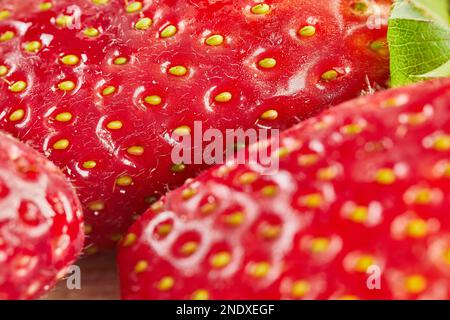 Fragole fresche selezionate, impilate su fondo in legno. Primo piano. Foto Stock
