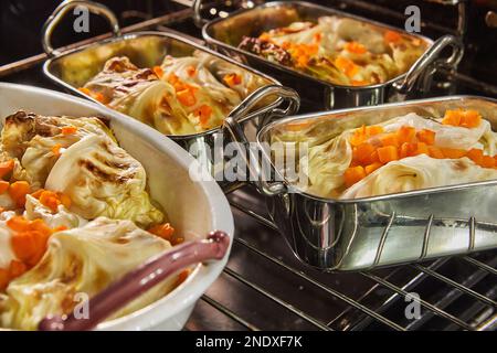 I involtini di cavolo con salmone, carote e salsa vengono cotti al forno. Ricetta francese. Foto Stock