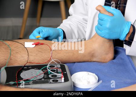 Elettromiografia negli arti inferiori, tecnica di registrazione grafica dell'attività elettrica prodotta dal muscolo tibiale eseguita da uno specialista ne Foto Stock