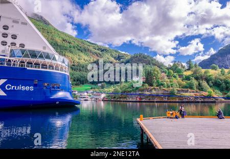 Flam, Norvegia, 17 2022 agosto: La poppa di una nave da crociera all'estremità interna di Aurlandsfjord, con il villaggio di Flam sullo sfondo. Foto Stock