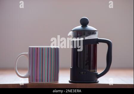 Una tazza di caffè e una caffetteria al mattino Foto Stock